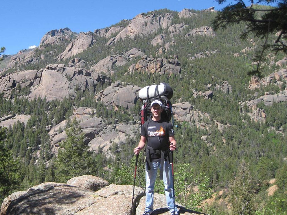 Man wearing backpacking gear on a mountain