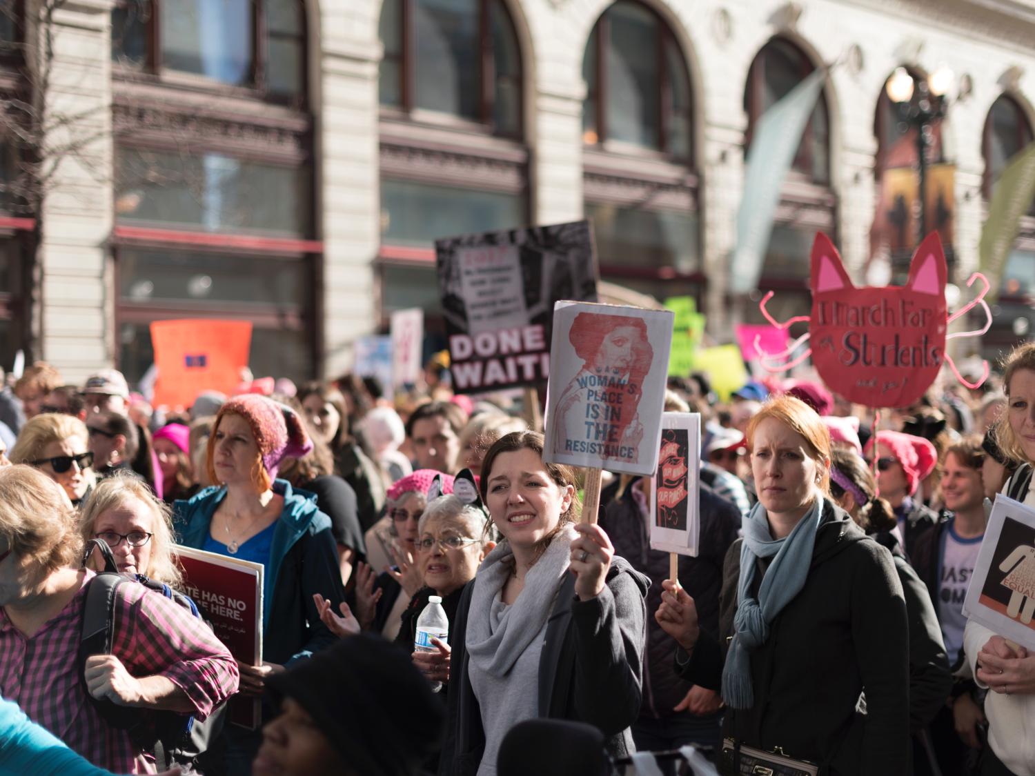 Several women gathered and holding signs at the 2017 Women's March