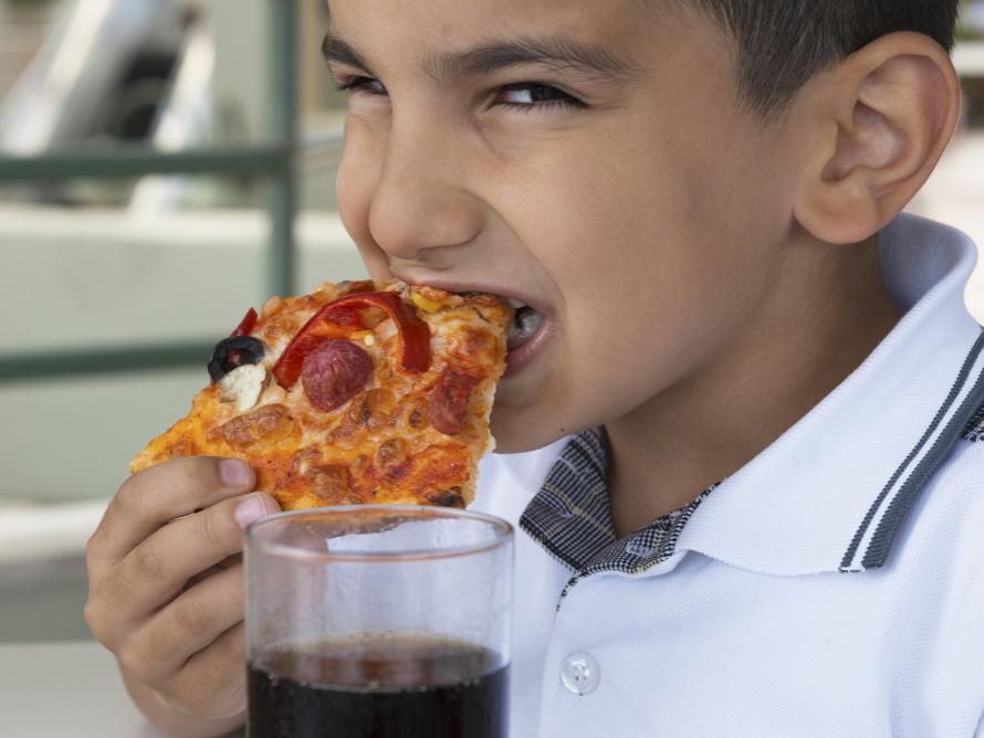 Latino child eating pizza