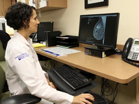 A physician views a breast scan on a computer.