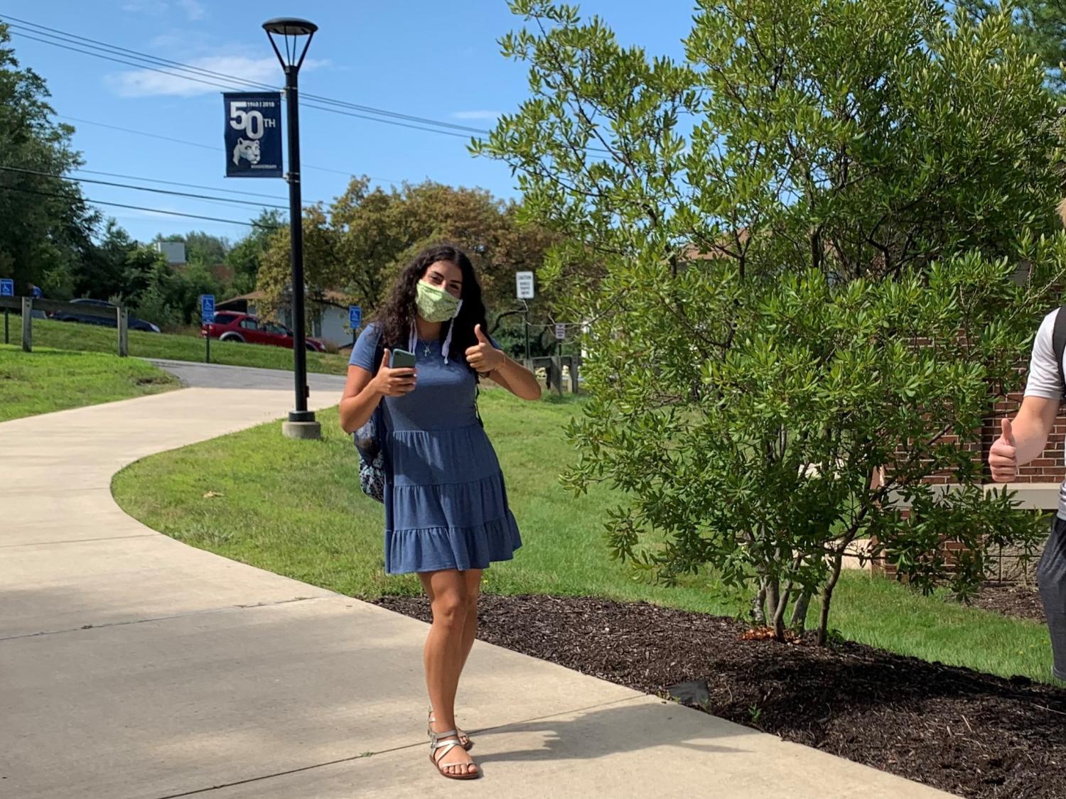 students wearing masks give a thumbs up sign 