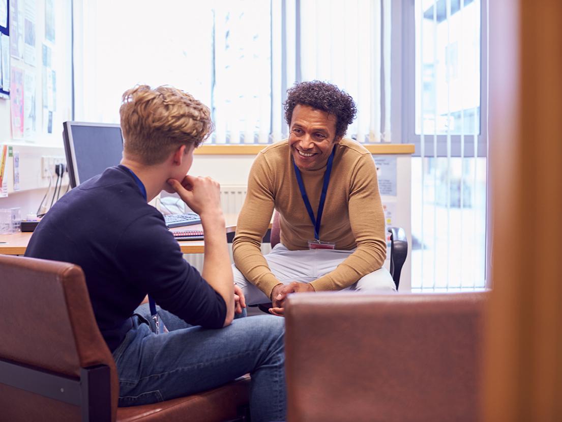 mentor has a conversation in office with student