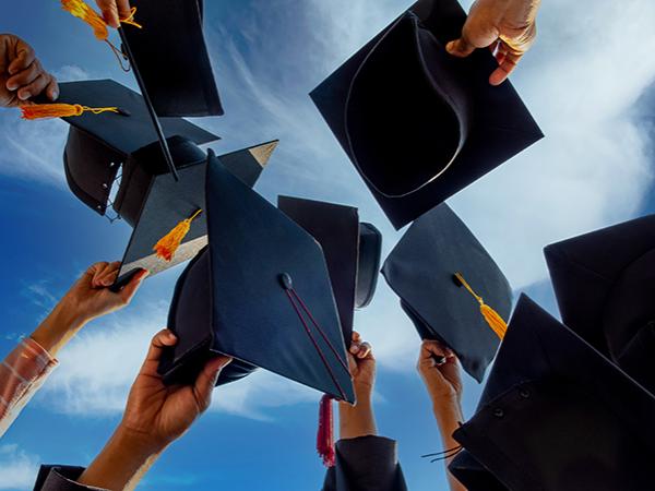 Graduates holding their caps in the air