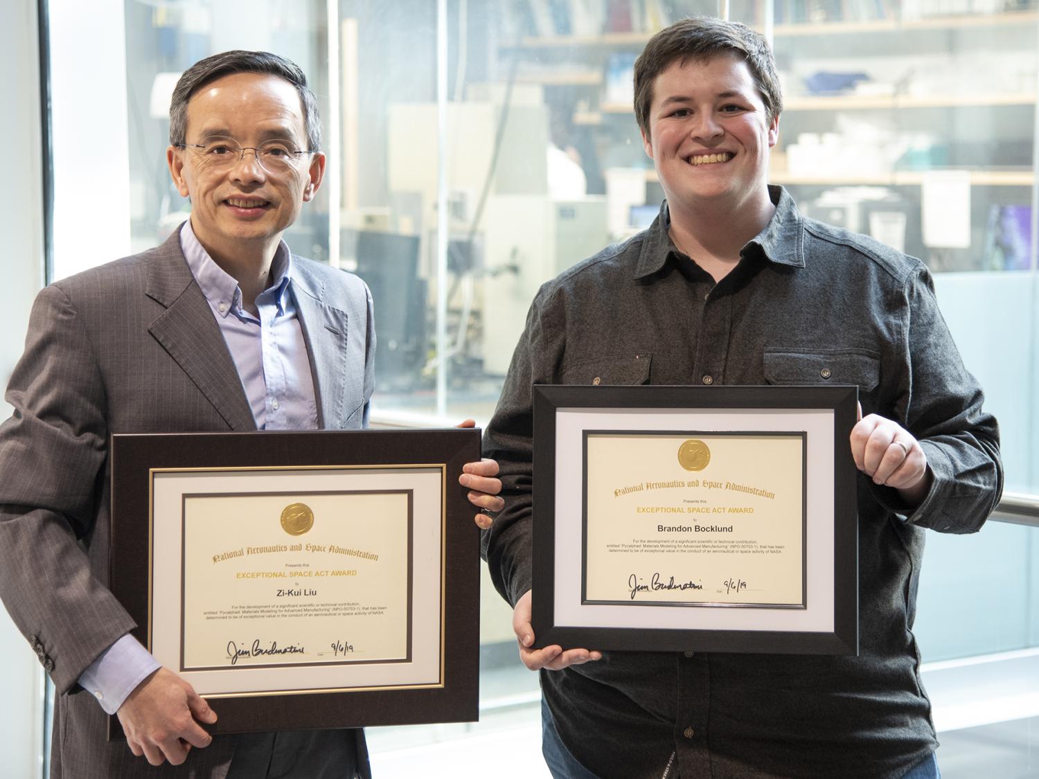 Zi-Kui Liu and Brandon Bocklund post with awards from NASA 