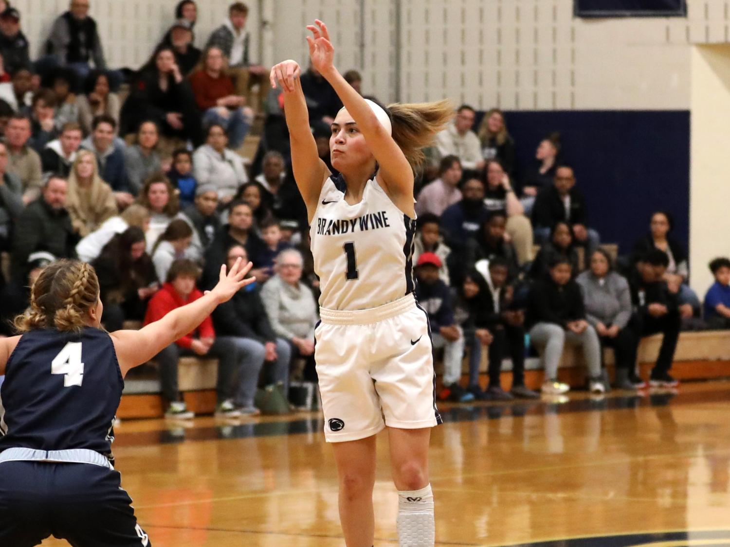 Nikki Velez sinks a three-pointer over the out-stretched arm of a defender