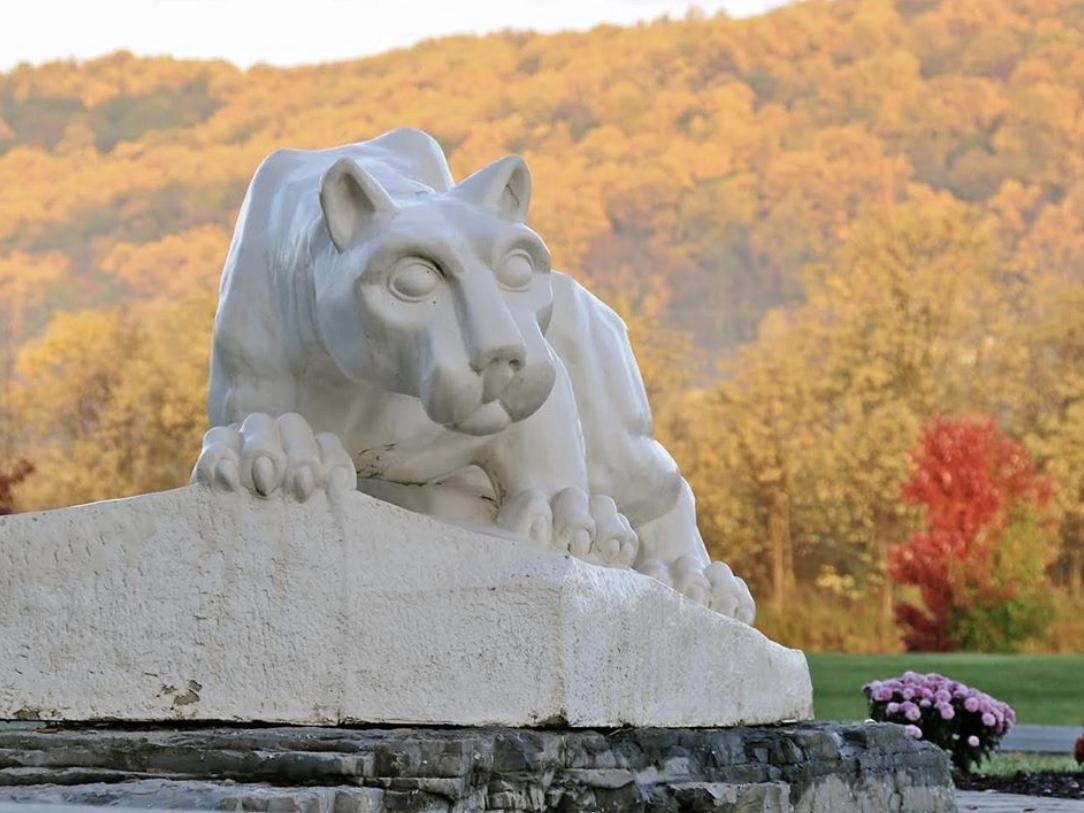 Nittany Lion statue shrine with fall foliage mountain backdrop