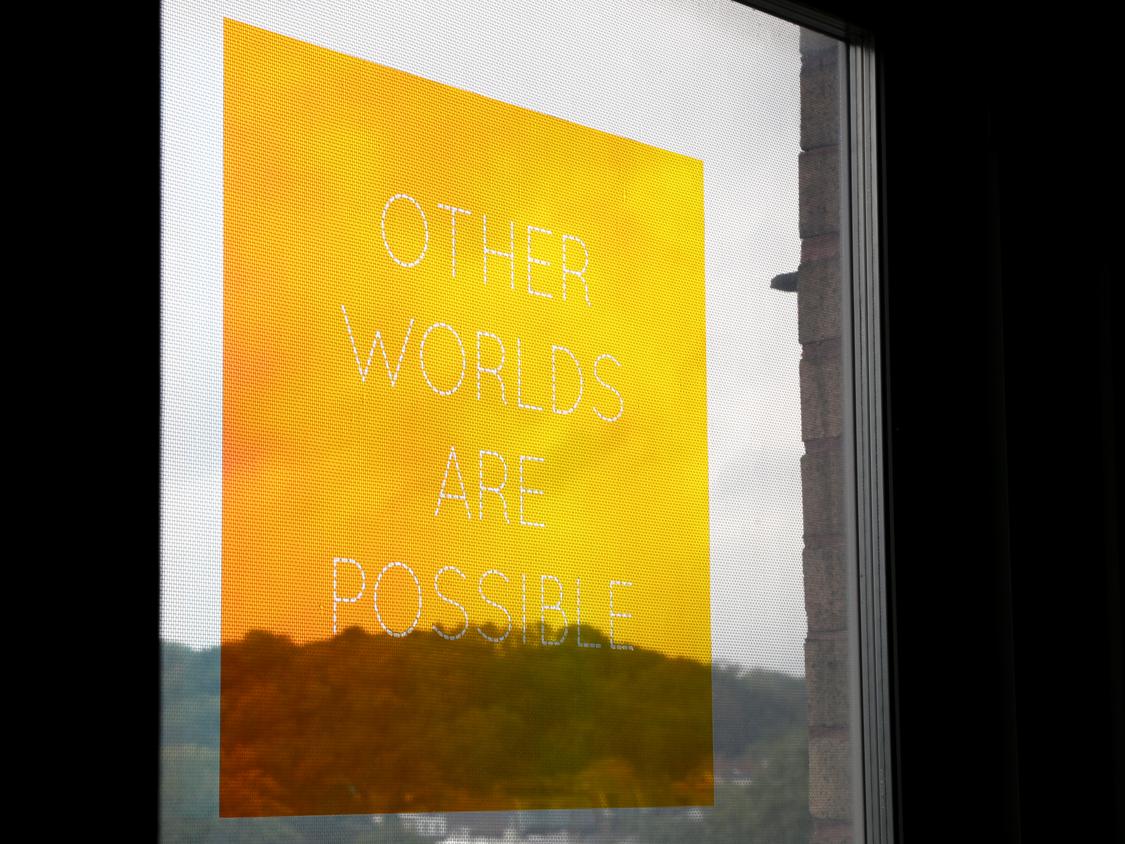 Other Worlds Are Possible text on window