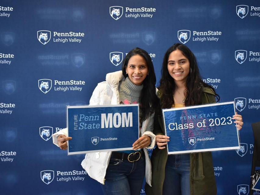 two women holding penn state signs