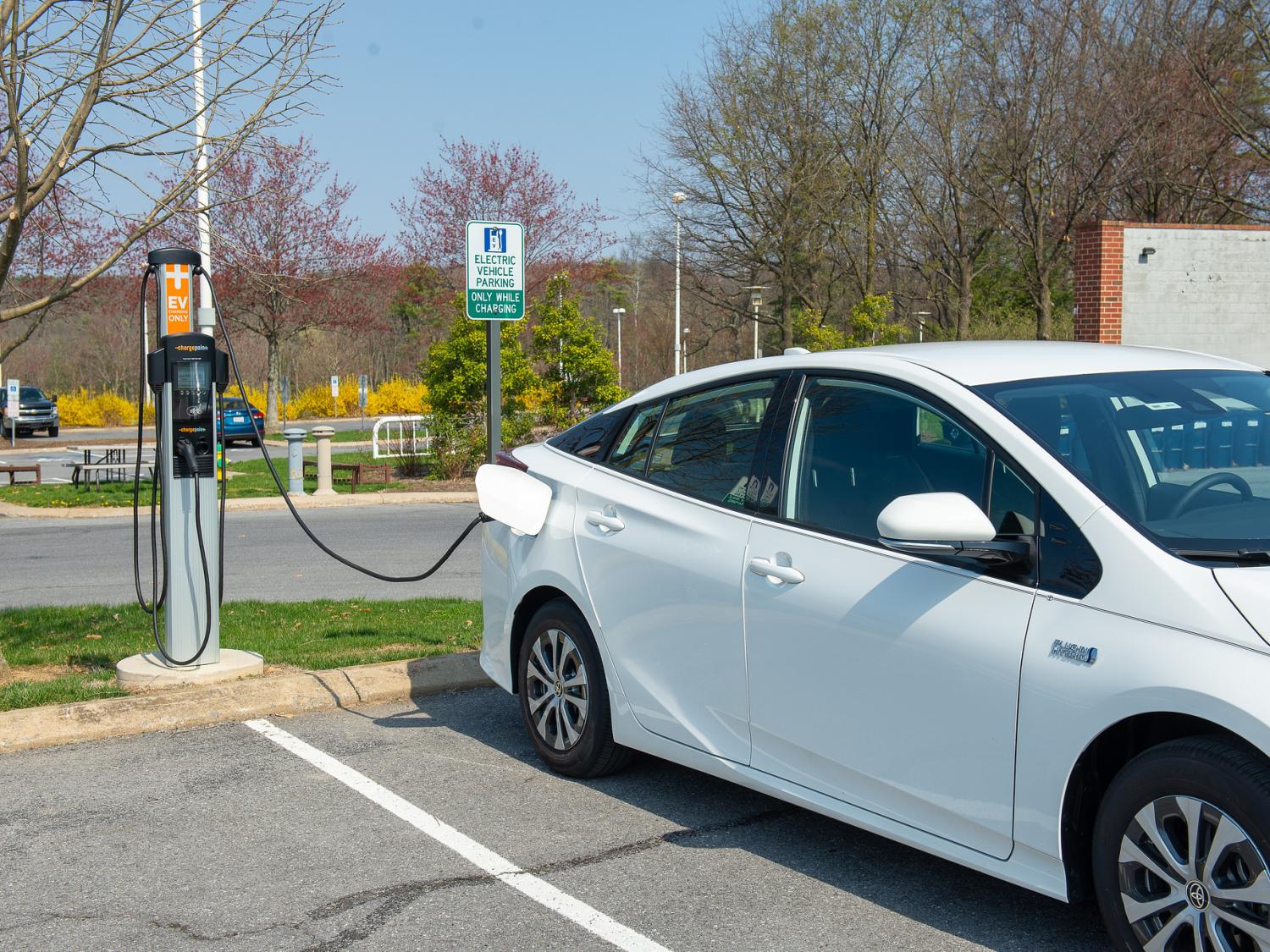 a white car plugged into an outdoor electric vehicle charging station