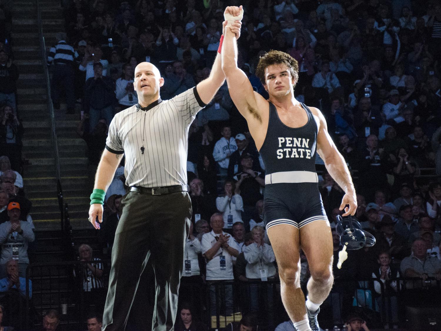 A referee raises Penn State wrestler Morgan McIntosh's hand in victory