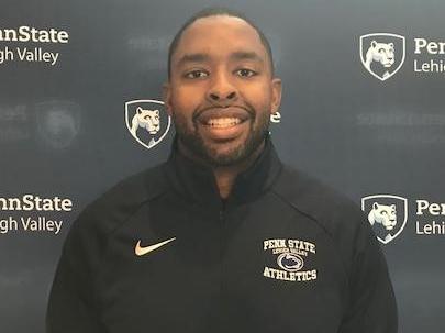 head shot of man in front of step and repeat banner