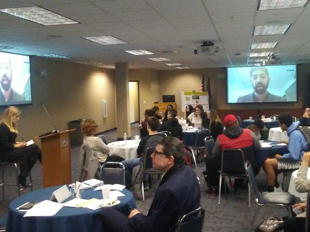 Group listening to a speaker on a screen