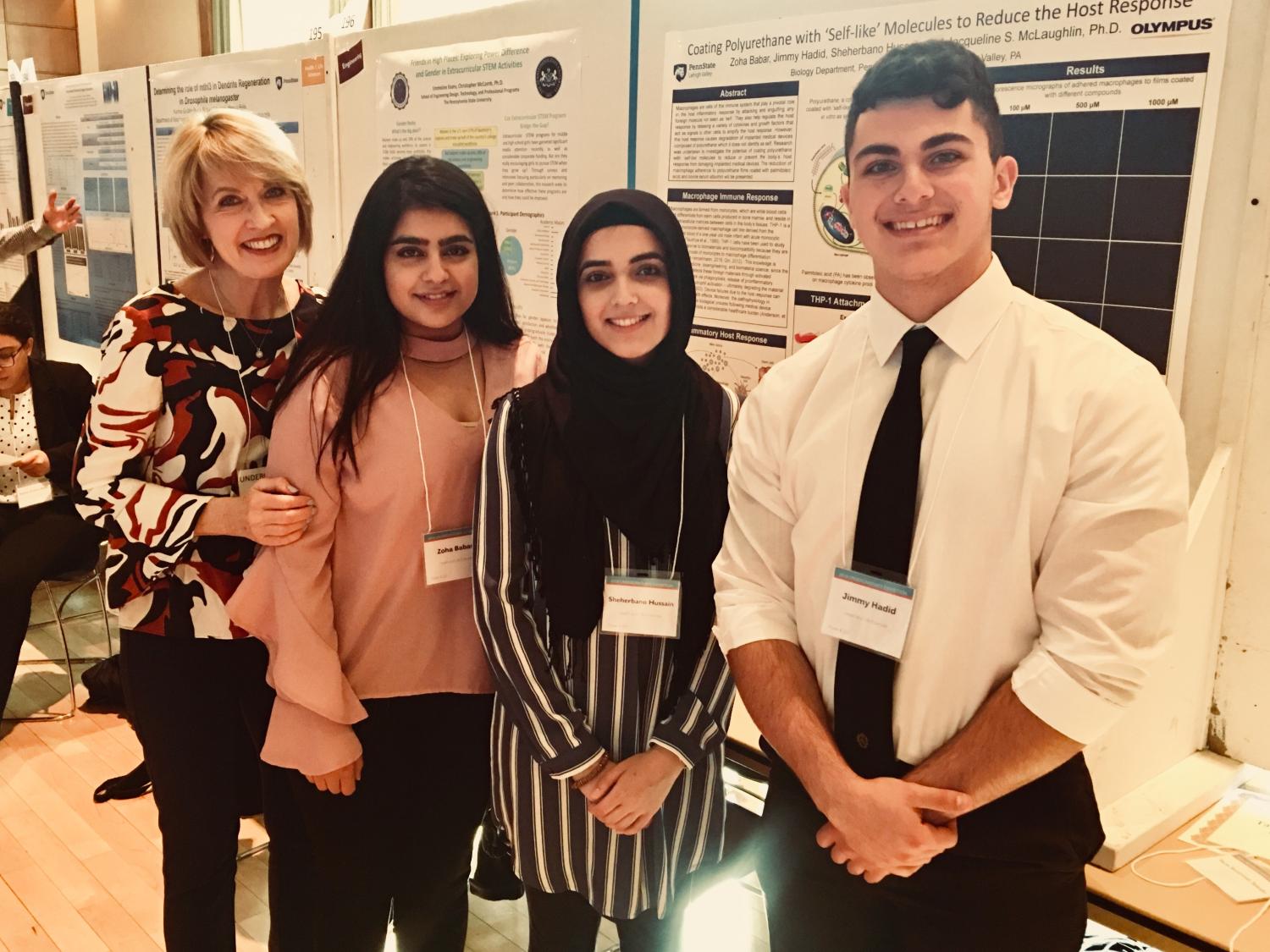 professor and students in front of research poster