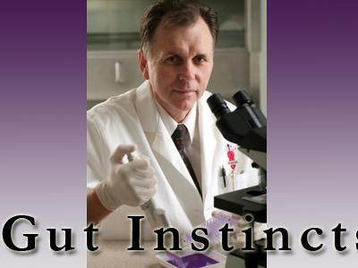 picture of man in white coat at microscope