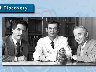 three men sitting around a heart assist pump