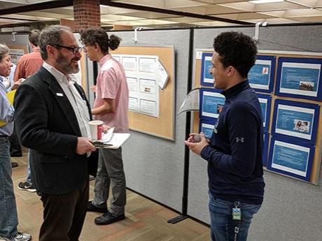 Alonzo Williams discusses his product with Michael Polgar, associate professor of sociology, during the annual research fair at Penn State Hazleton.