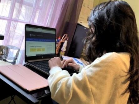 Psychology graduate Gina Romano goes over some of her research at her home desk on her laptop