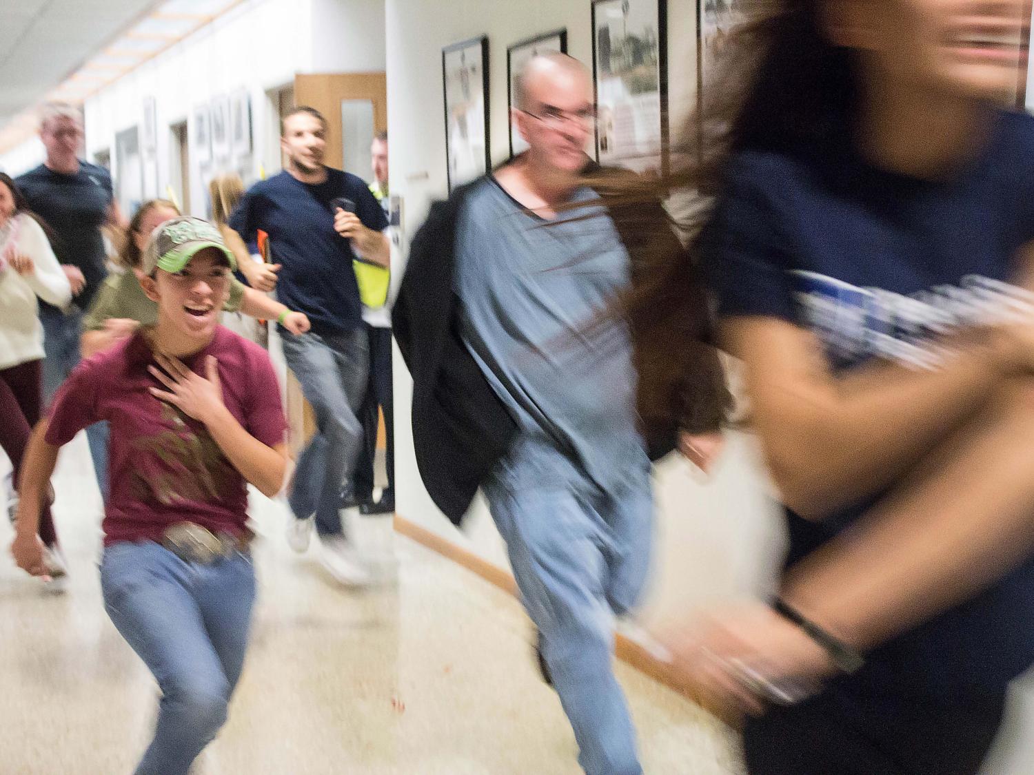 Students flee the building during an active shooter training drill at Penn State Beaver.