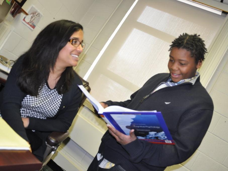 student standing with instructor seated