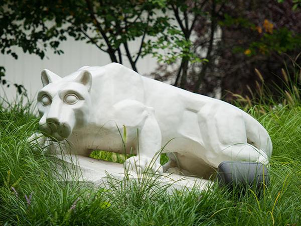 Lion statue surrounded by tall grass