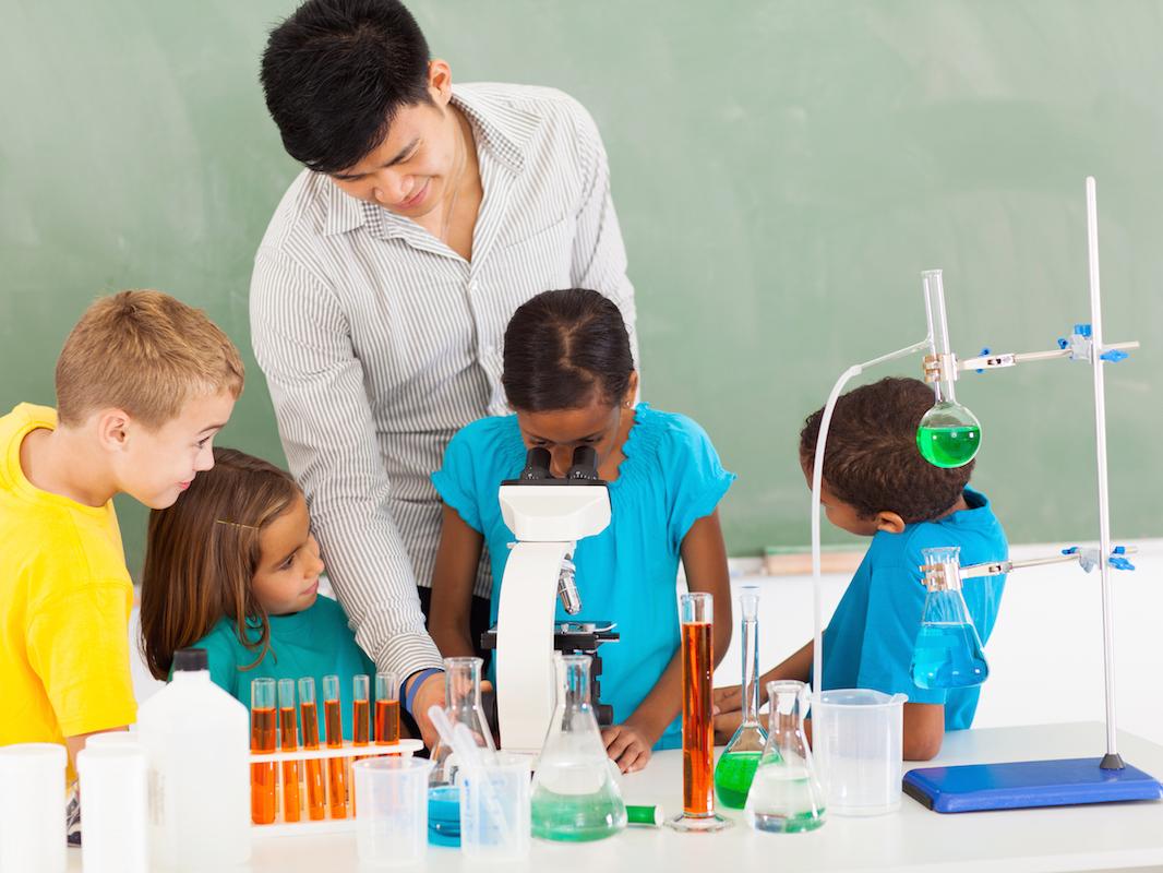 Primary teacher and students in science class