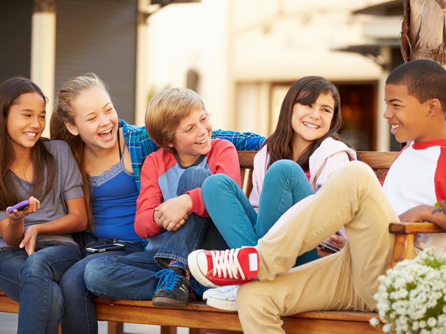group of children sitting on bench in mall