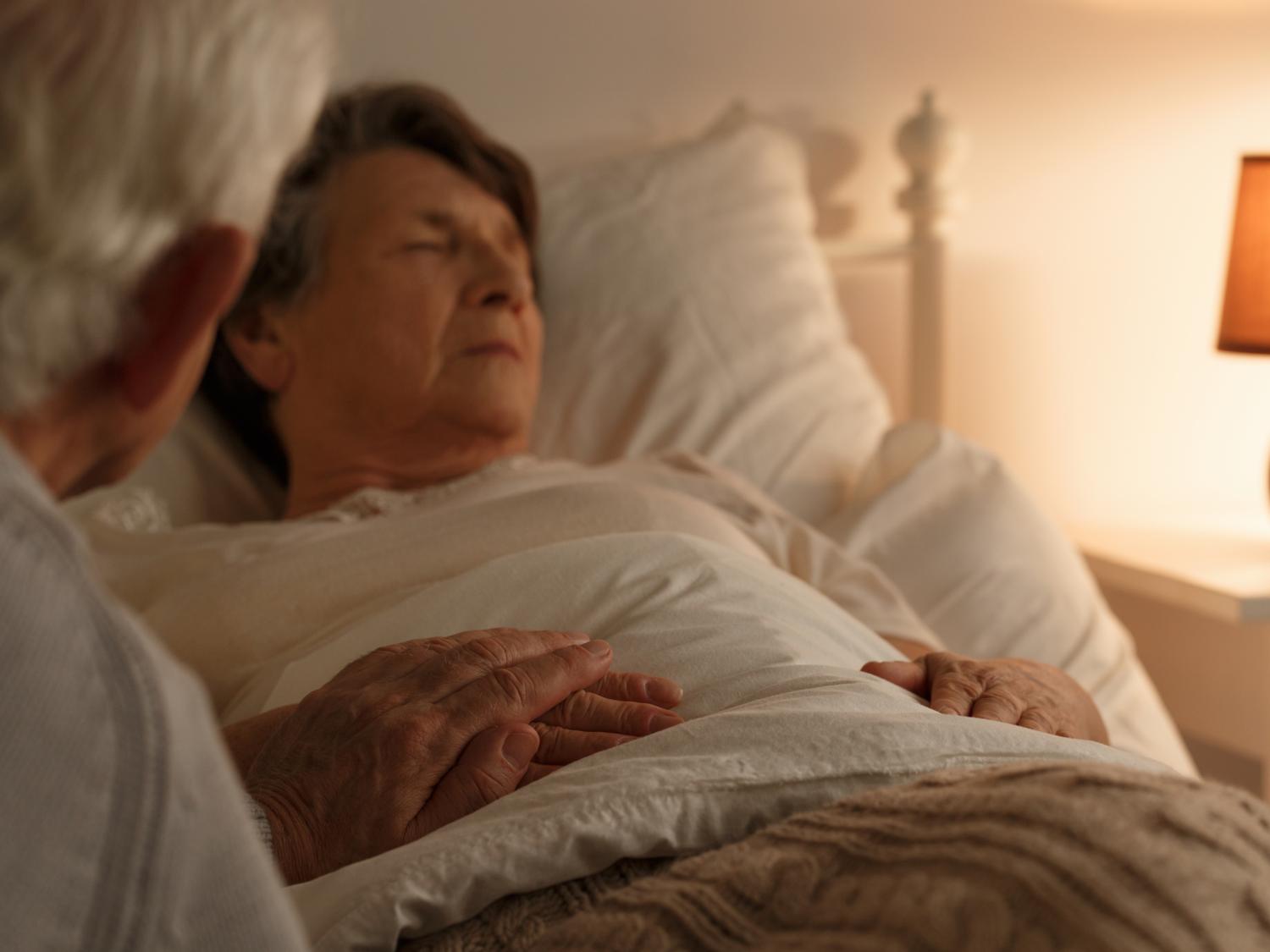 Husband holding hand of his ill wife