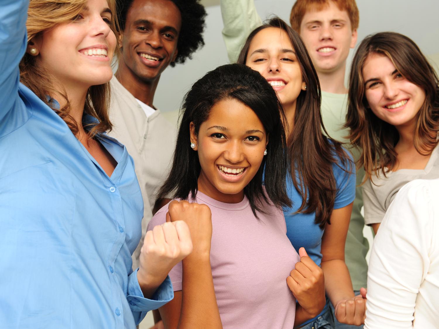 excited and happy group of diverse young people cheering