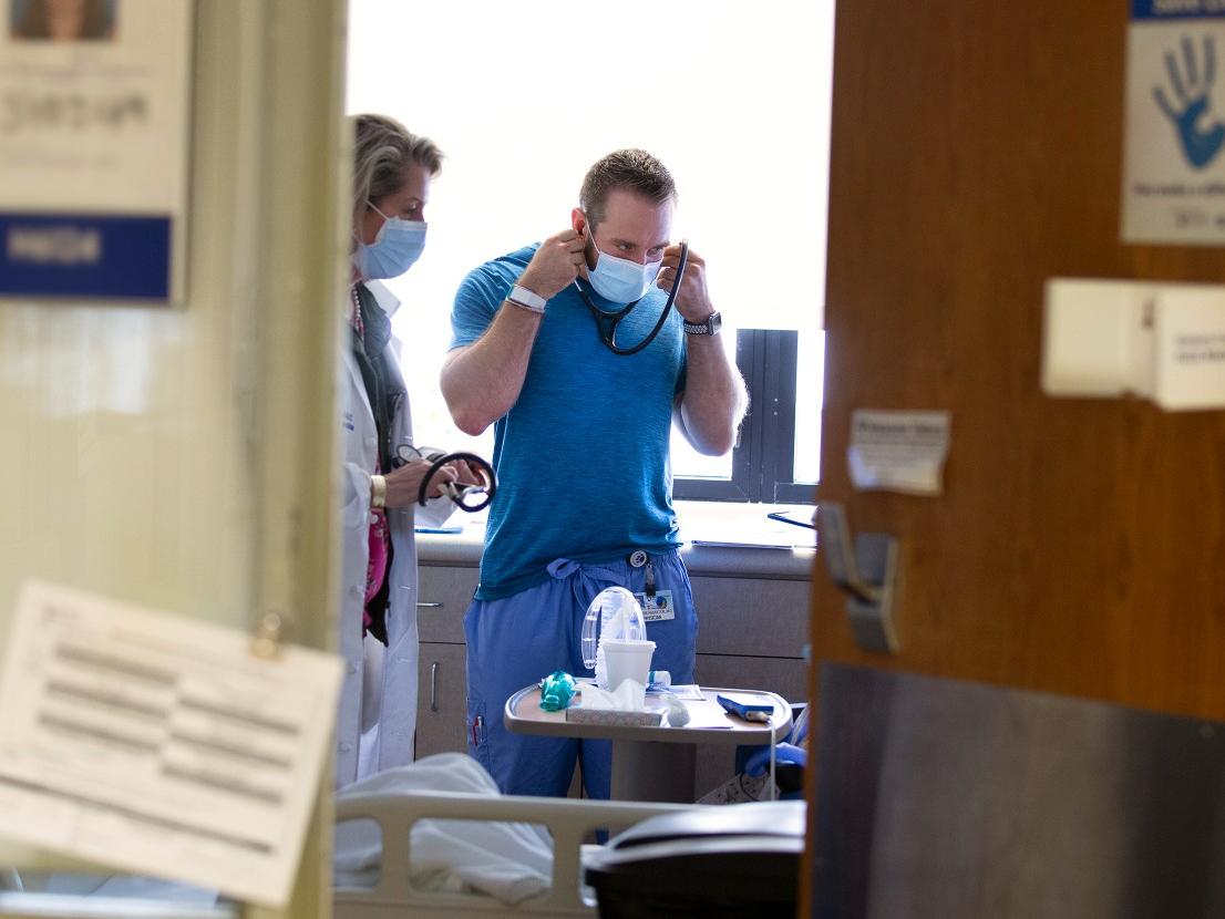 Two doctors stand in a patient room at Penn State Health Milton S. Hershey Medical Center. 