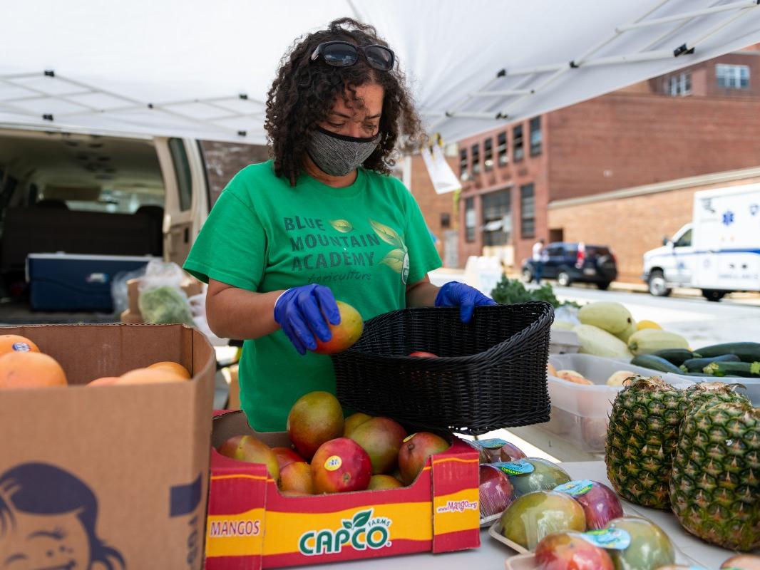 Christina Houston, a staff member of Blue Mountain Academy, arranges produce to be sold at the farm stand at Penn State Health St. Joseph Downtown Campus.