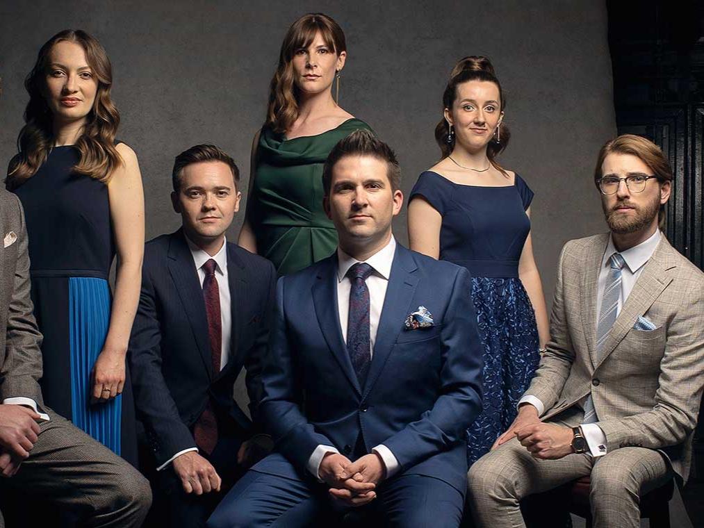 A group of men and women pose for a formal photo.