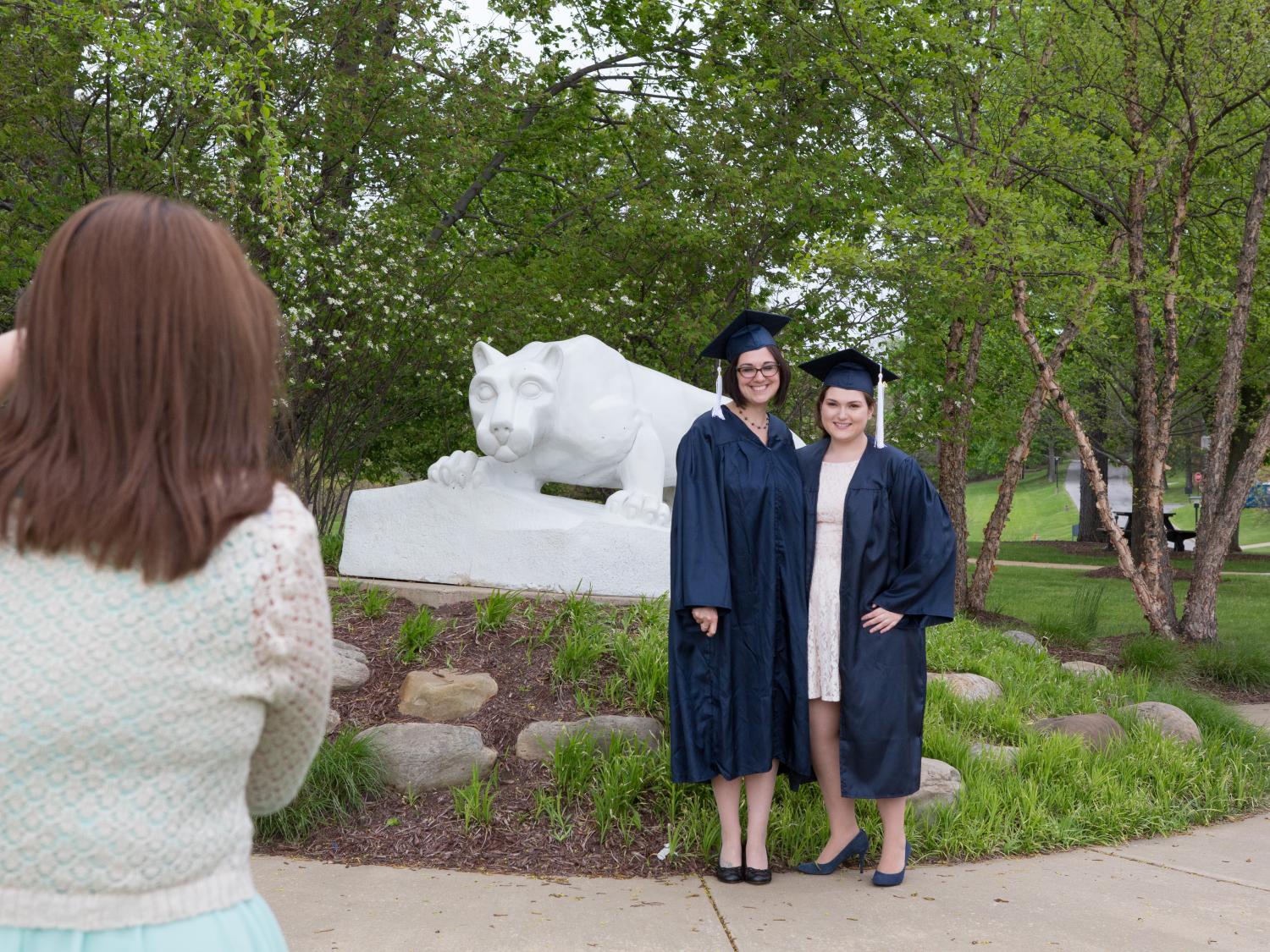 graduates posing at lion shrine