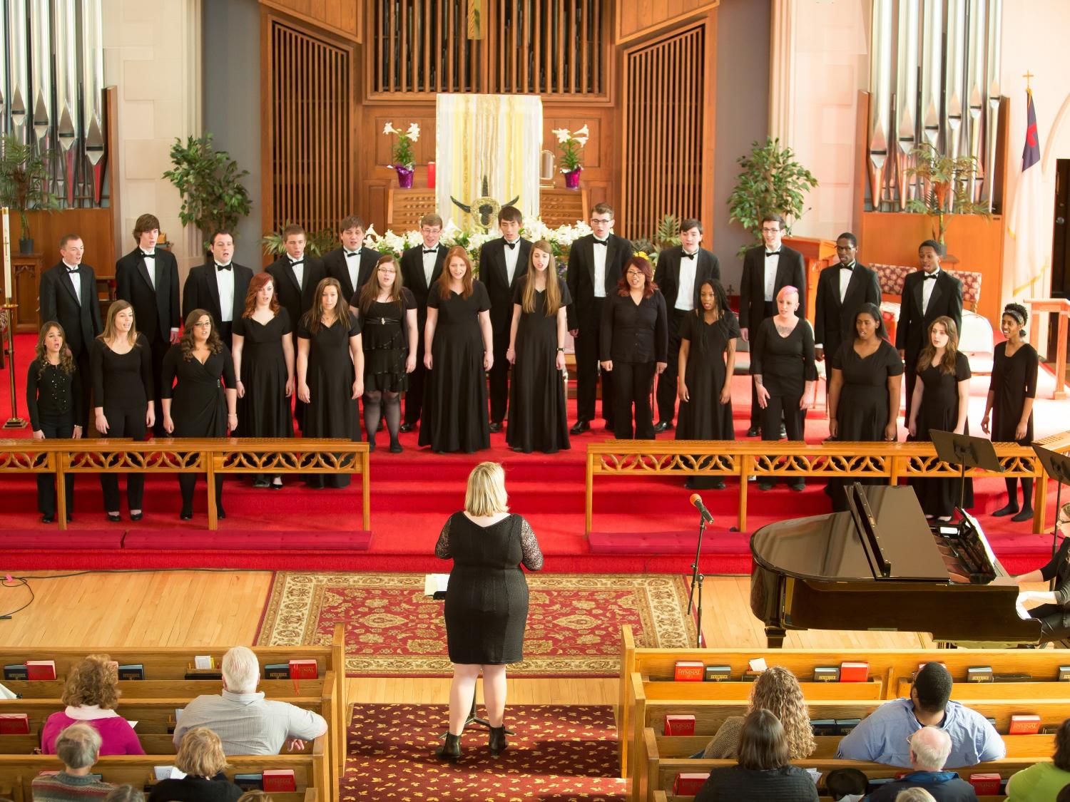 The Penn State Behrend choir sings in a church