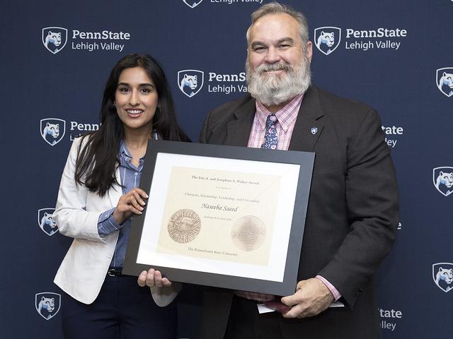 female student accepting award from man