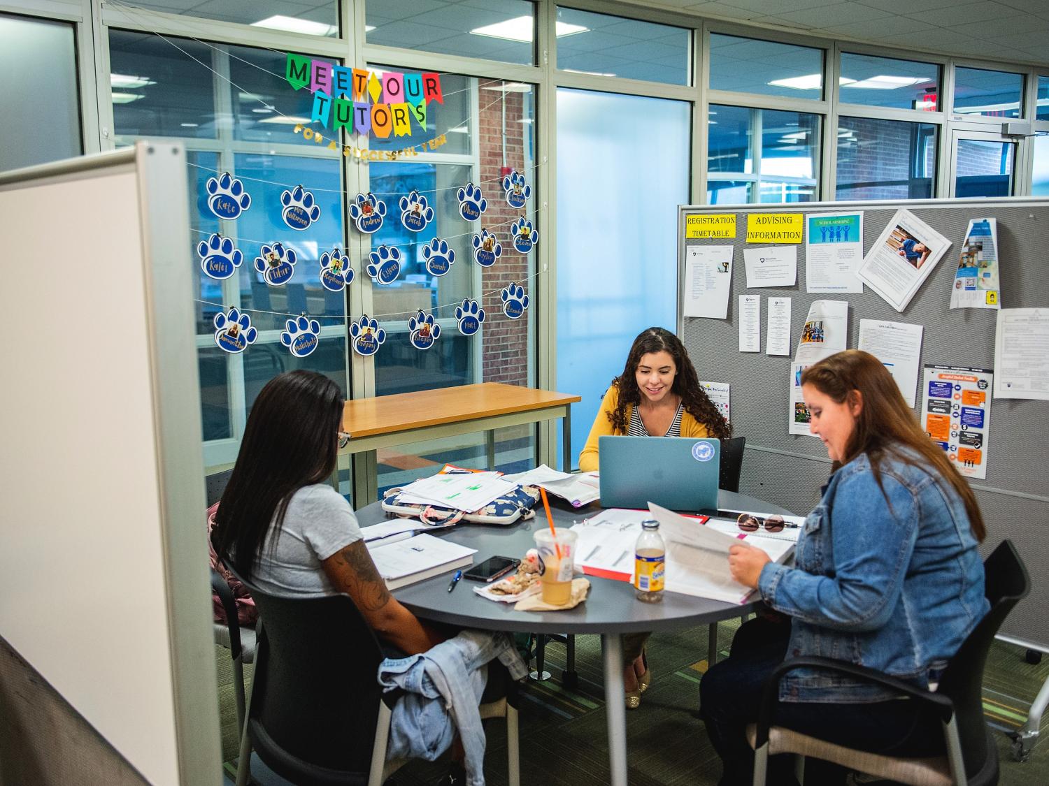 student tutors at table working in the learning center