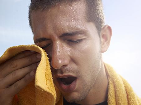 A man wipes off sweat after a workout.