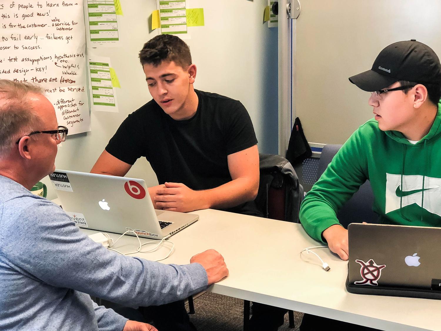Michael Khorosh and Emir Myrzabekov consult with their internship coordinator, Surge founder Kerry Small at Happy Valley Launchbox.