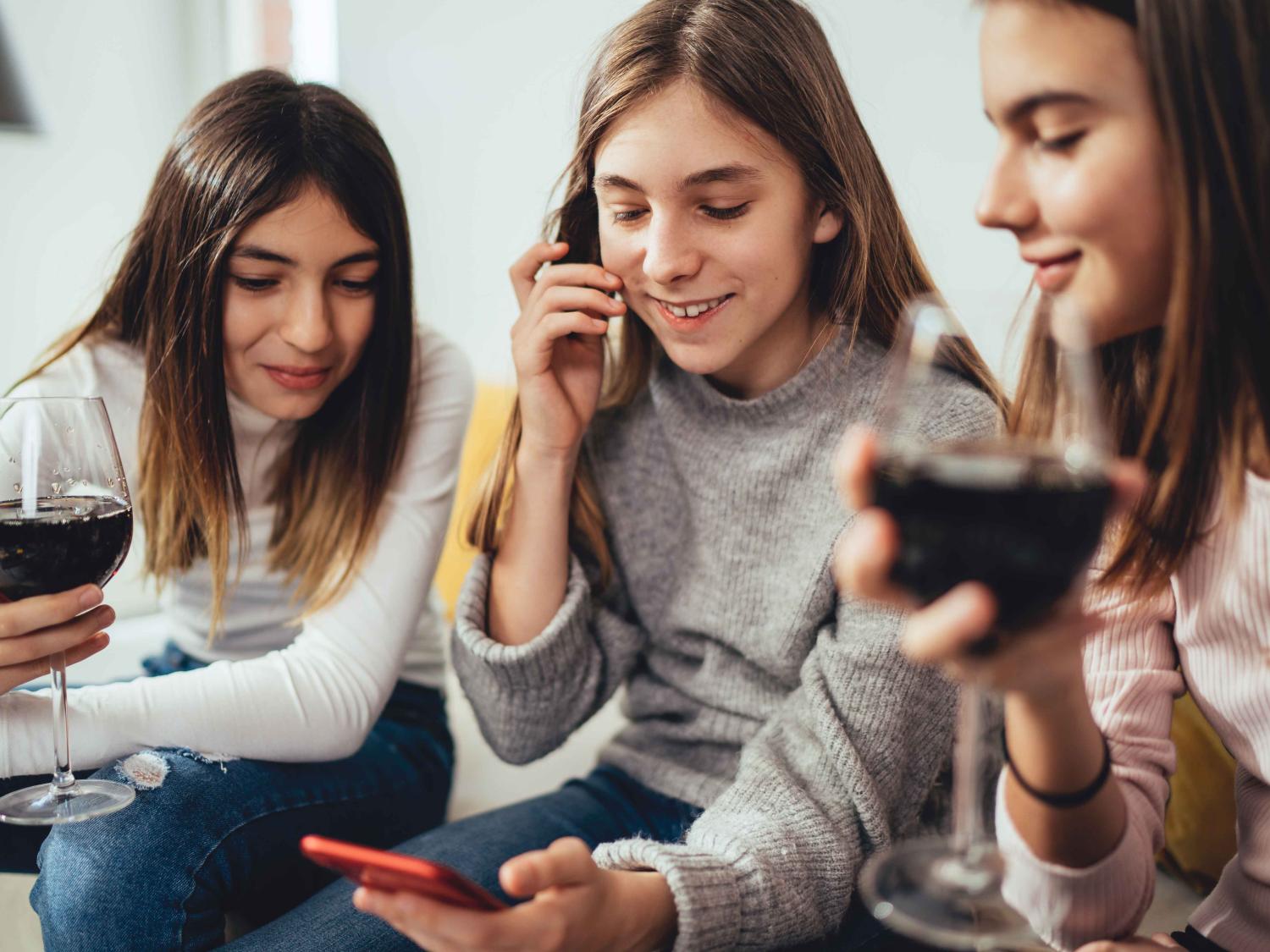 three teen girls drinking wine