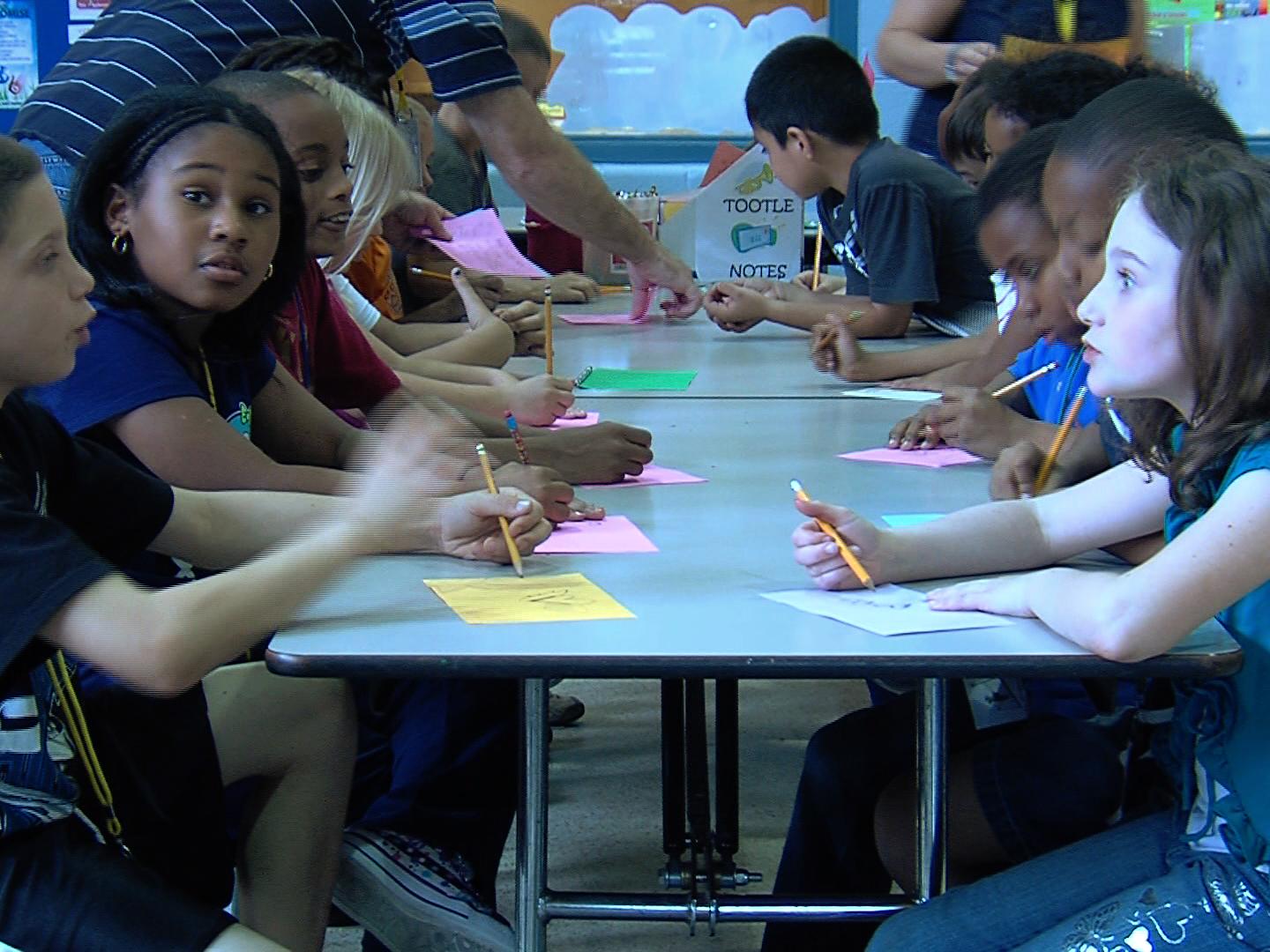 children at table, drawing and talking