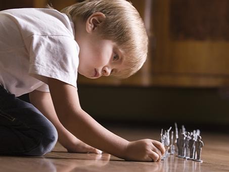 A child plays with toys on the floor.