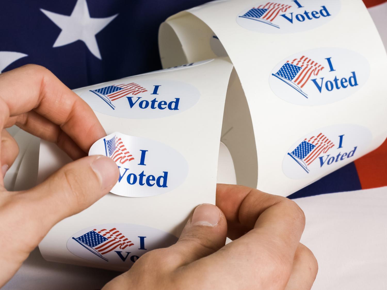 Hand grabbing an I Voted sticker