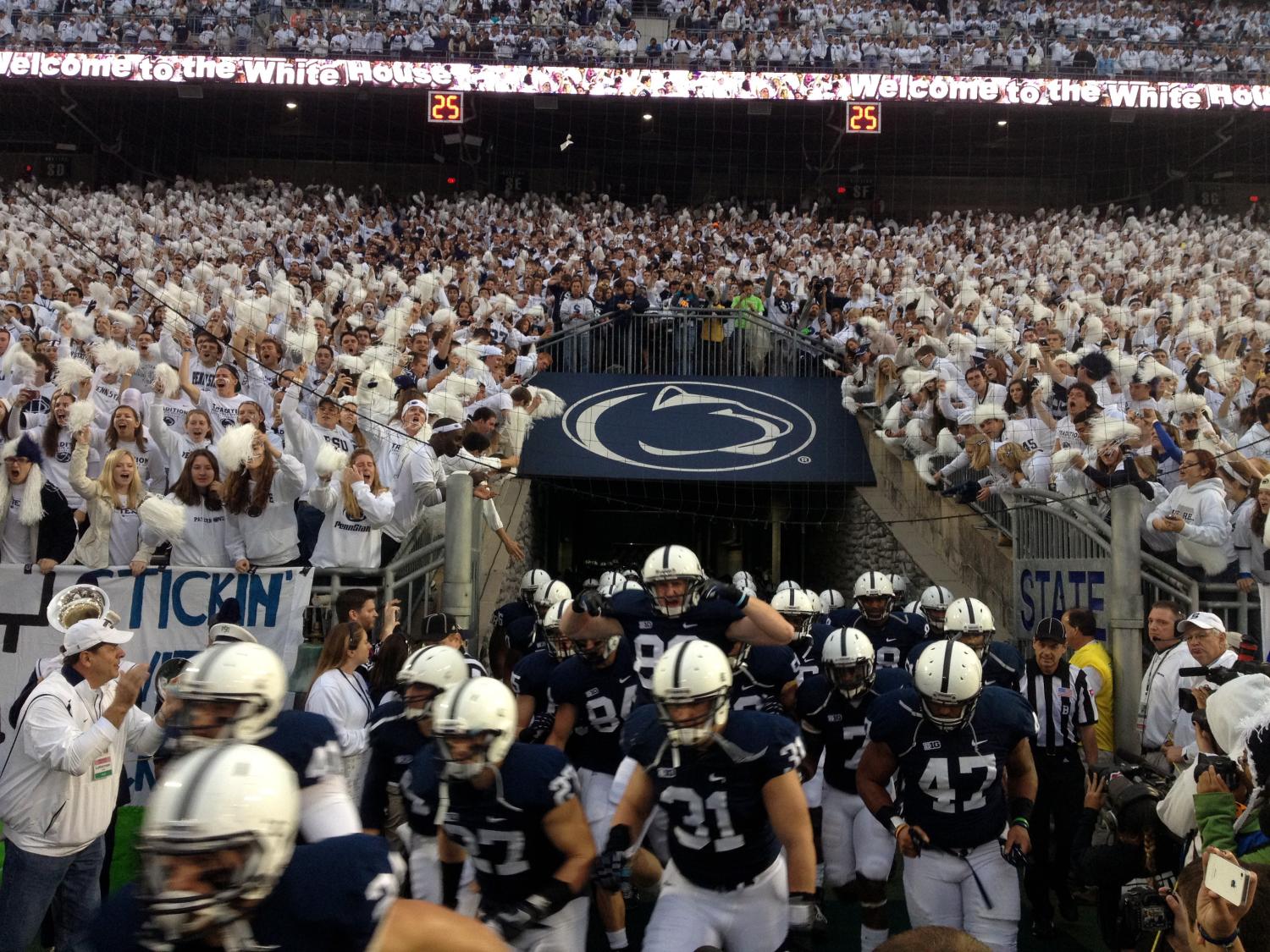 Penn State football team members run onto the field before a 2012 game at Beaver Stadium