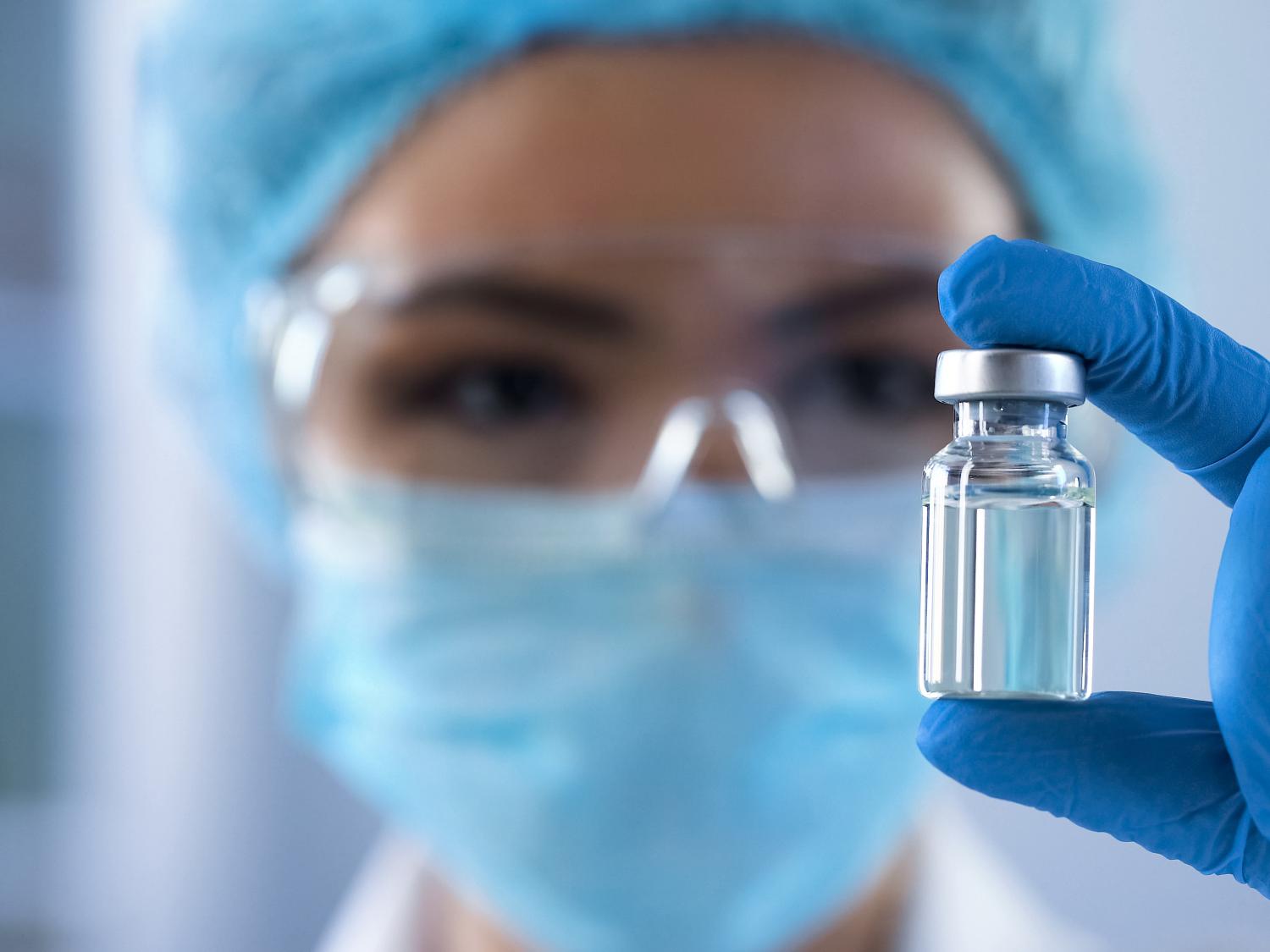 A researcher examines a glass bottle