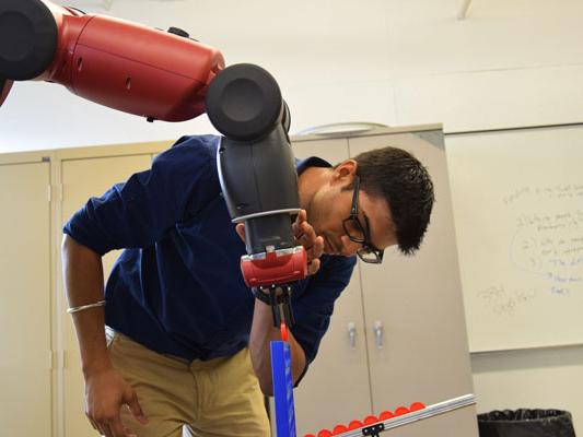 Aerospace engineering Ph.D. student Mollik Nayyar calibrates a robot to play an interactive game in the Robot Ethics and Aerial Vehicles Laboratory.