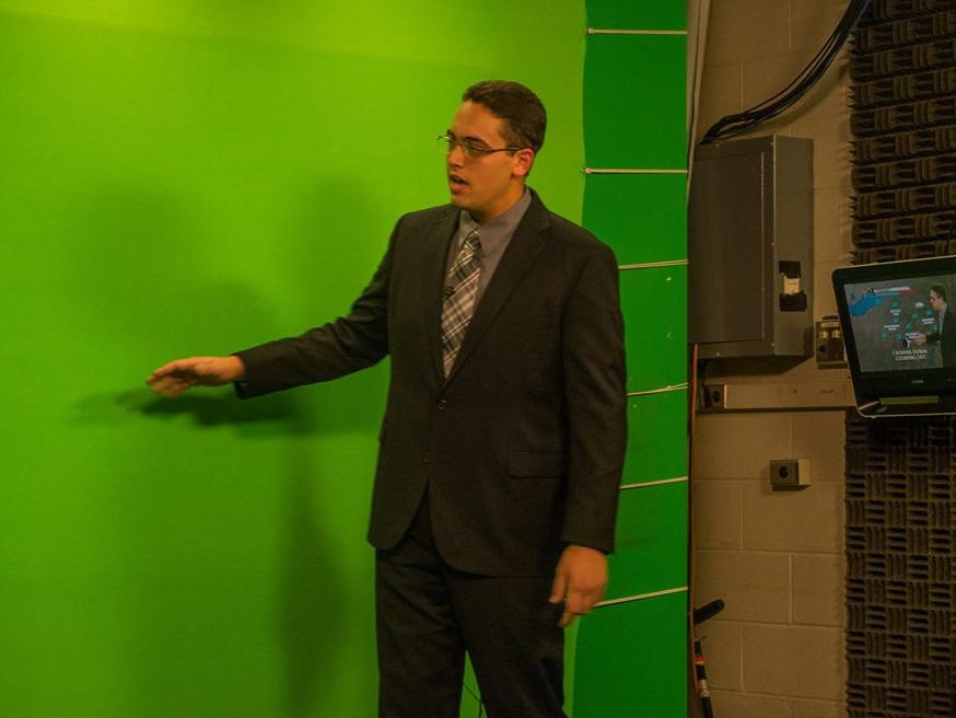 Penn State meteorology student Ben Reppert delivers a forecast in front of the "green screen"