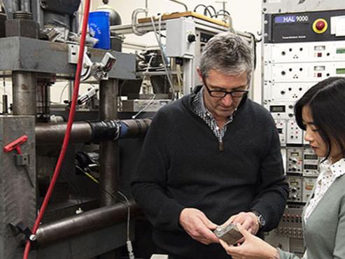 Two researchers examine materials in a lab