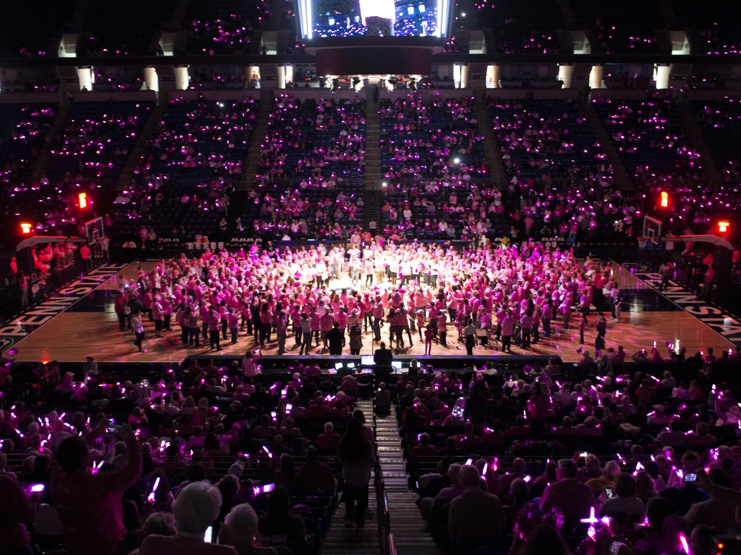 Hundreds of breast cancer survivors fill the basketball court at halftime of the Pink Zone game.