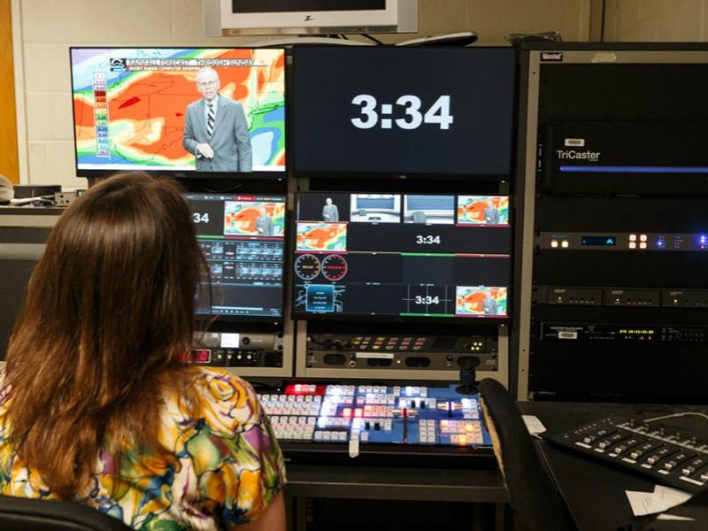 “Weather World” is on the air as seen through the studio control room.