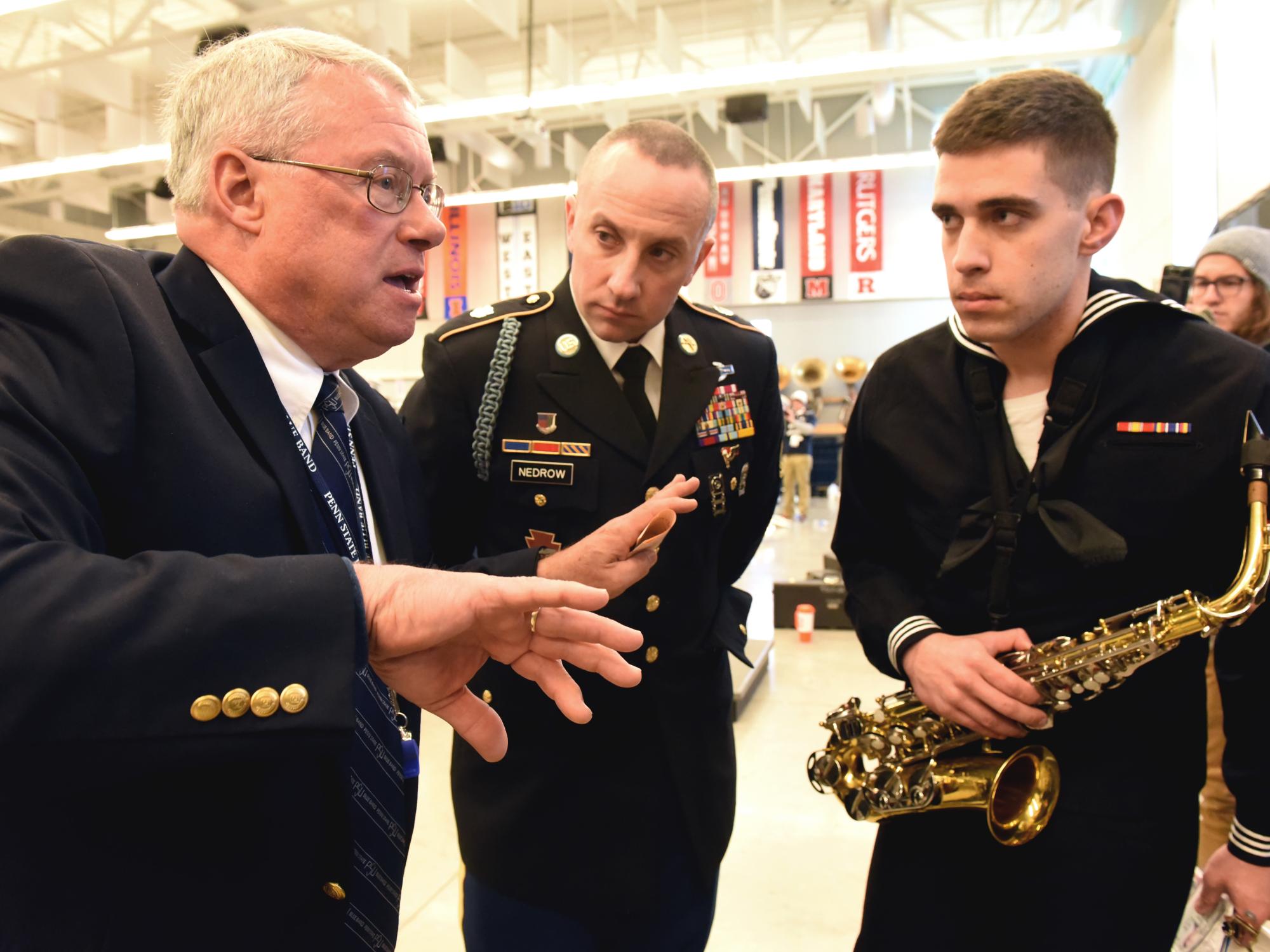 Dr. Bundy provides some final pre game instructions to two Blue Band alumni, now active-duty members of the military.