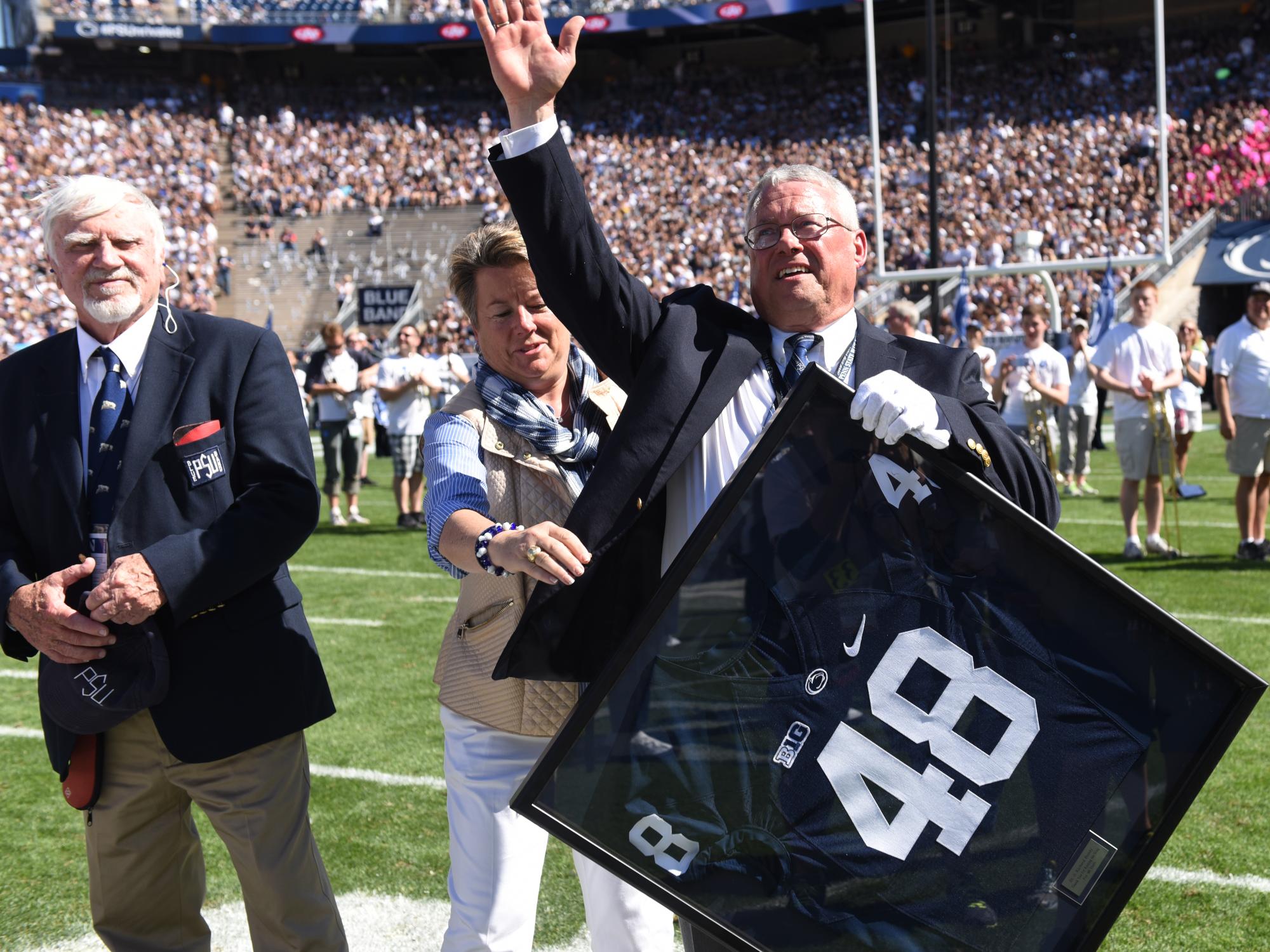 Dr. Bundy waves to the crowd after accepting a football jersey with the number 48.